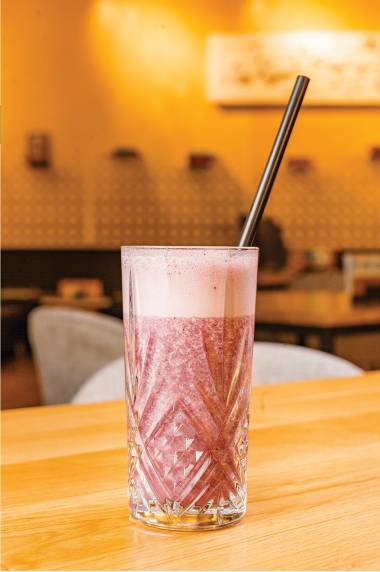 Glass of pink milkshake with a straw